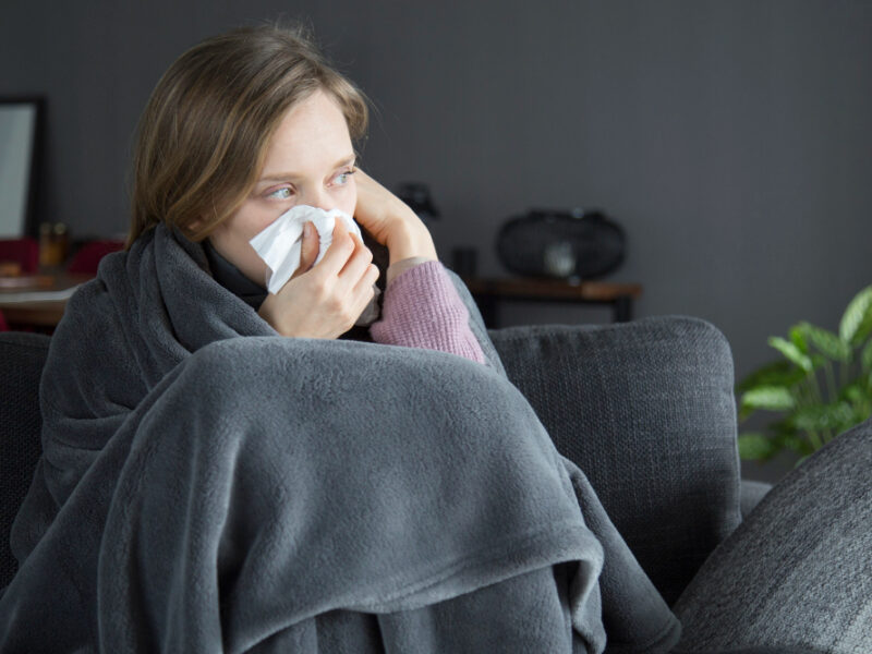 bored-sick-woman-holding-hand-head-blowing-nose-with-napkin